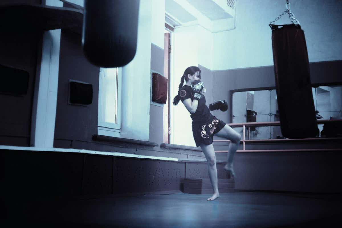 woman training for kickboxing with a punching bag